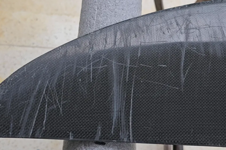 Close-up of deep scratches on a carbon wing